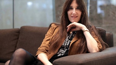 Zeruya Shalev lächelnd auf einer Couch | Bild: imago images
