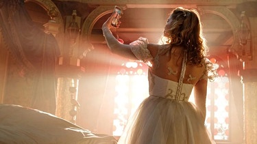 Junge Frau im Prinzessinnenkleid schaut auf ihr Handy | Bild: Constantin Film