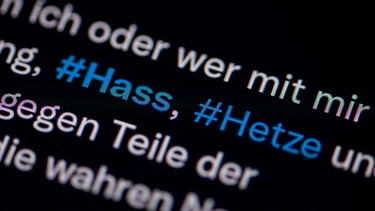 Auf dem Bildschirm eines Smartphones sieht man die Hashtags Hass und Hetze in einem Twitter-Post | Bild: picture alliance / dpa / Fabian Sommer